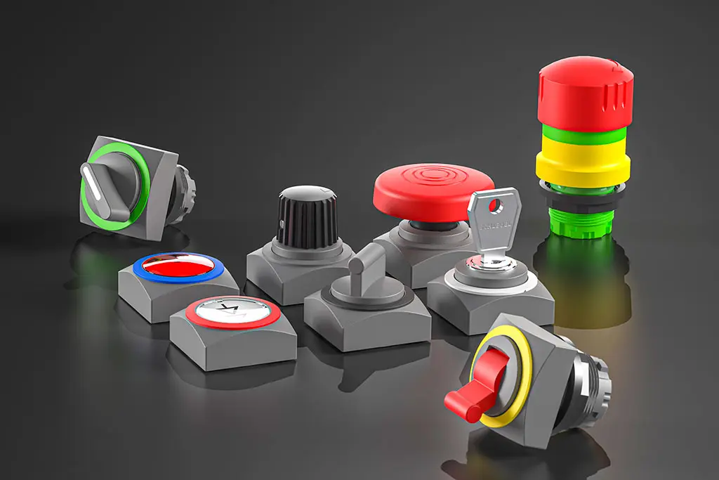 Not-Halt-Taster, quadratische Drucktasten, Schlüsselschalter und Wahlschalter auf einer schwarz-spiegelnden Oberfläche. Manche Taster liegen, andere stehen.