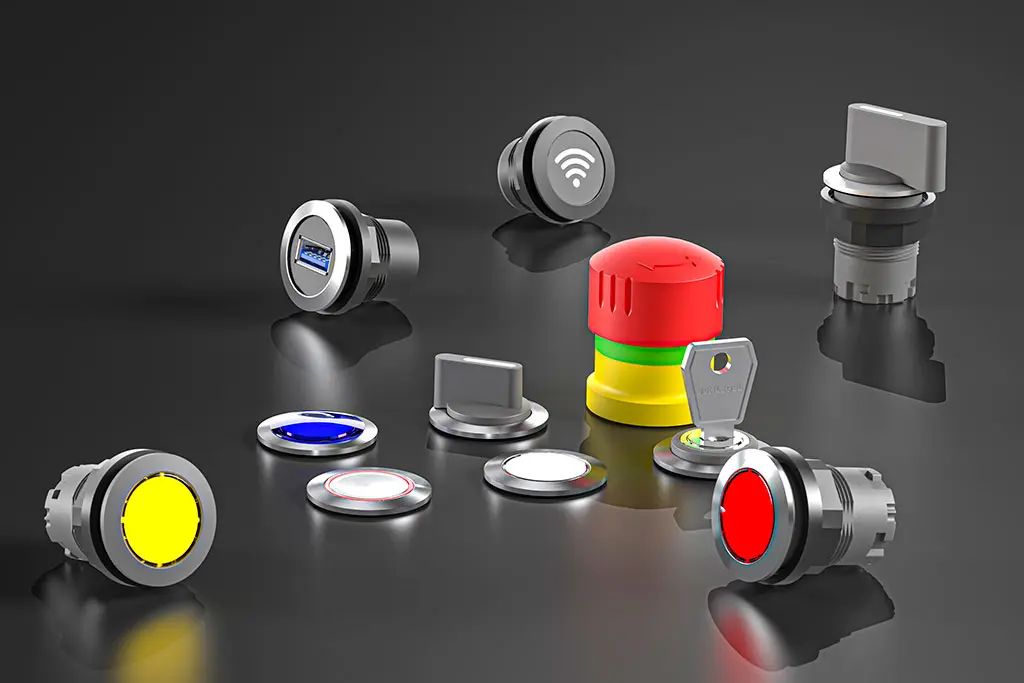 Not-Halt-Taster, Drucktasten, Schlüsselschalter und Wahlschalter auf einer schwarz-spiegelnden Oberfläche. Manche Taster liegen, andere stehen.