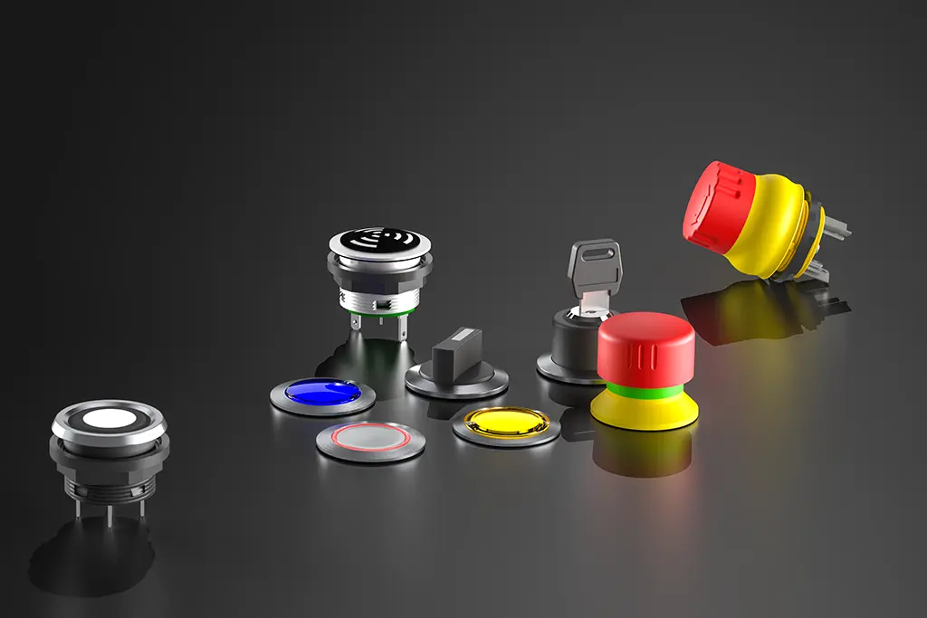 Not-Halt-Taster, Drucktasten, Schlüsselschalter und Wahlschalter auf einer schwarz-spiegelnden Oberfläche. Manche Taster liegen, andere stehen.