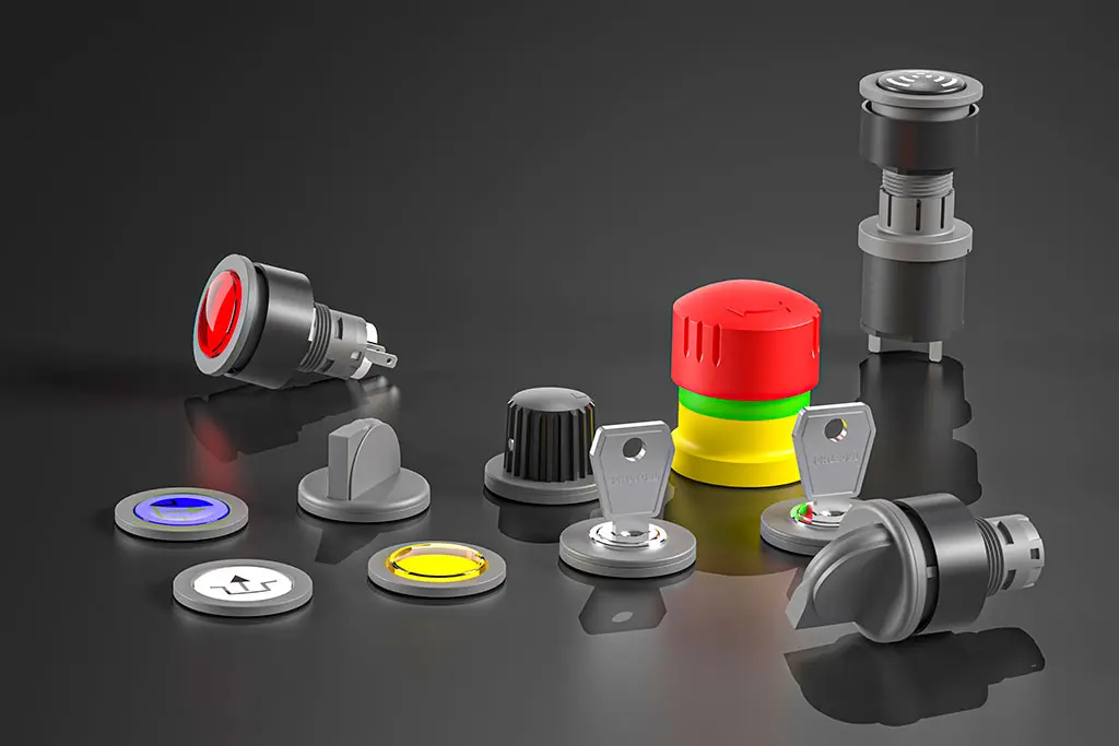 Not-Halt-Taster, Drucktasten, Schlüsselschalter und Wahlschalter auf einer schwarz-spiegelnden Oberfläche. Manche Taster liegen, andere stehen.